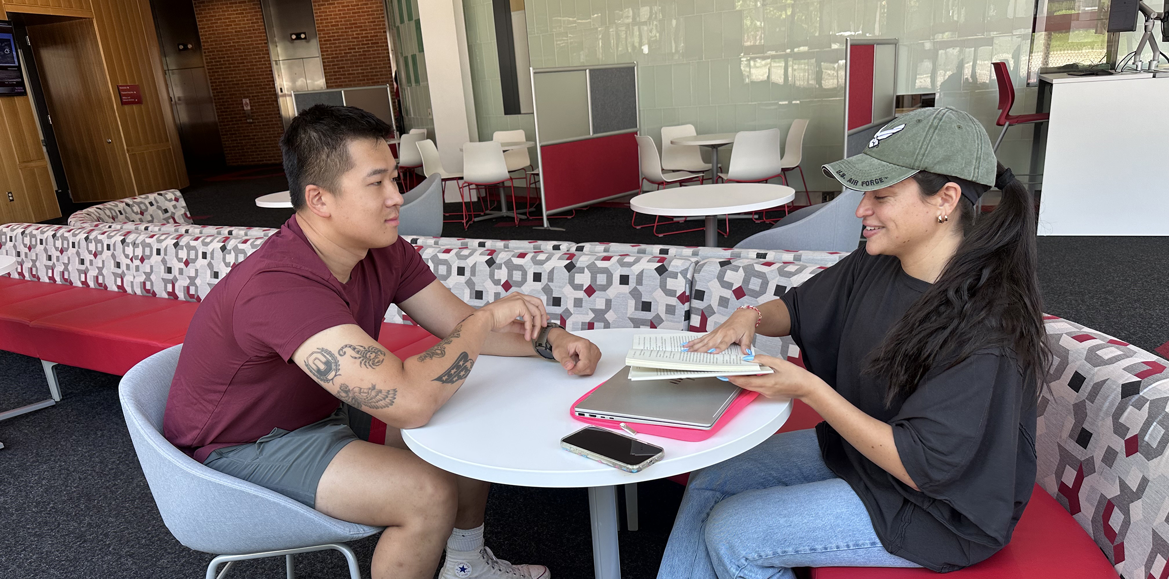 Two students sitting at a table and having a conversation