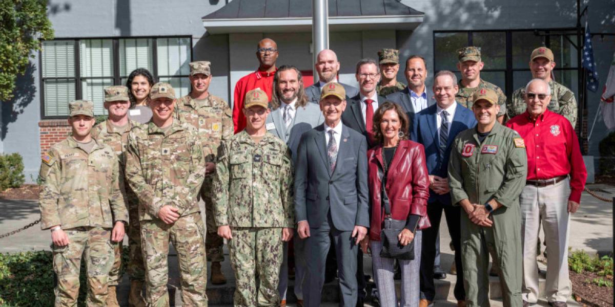 President Carter stands with military, ROTC and veterans services representatives.